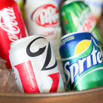 assorted cans of soda in a bucket of ice